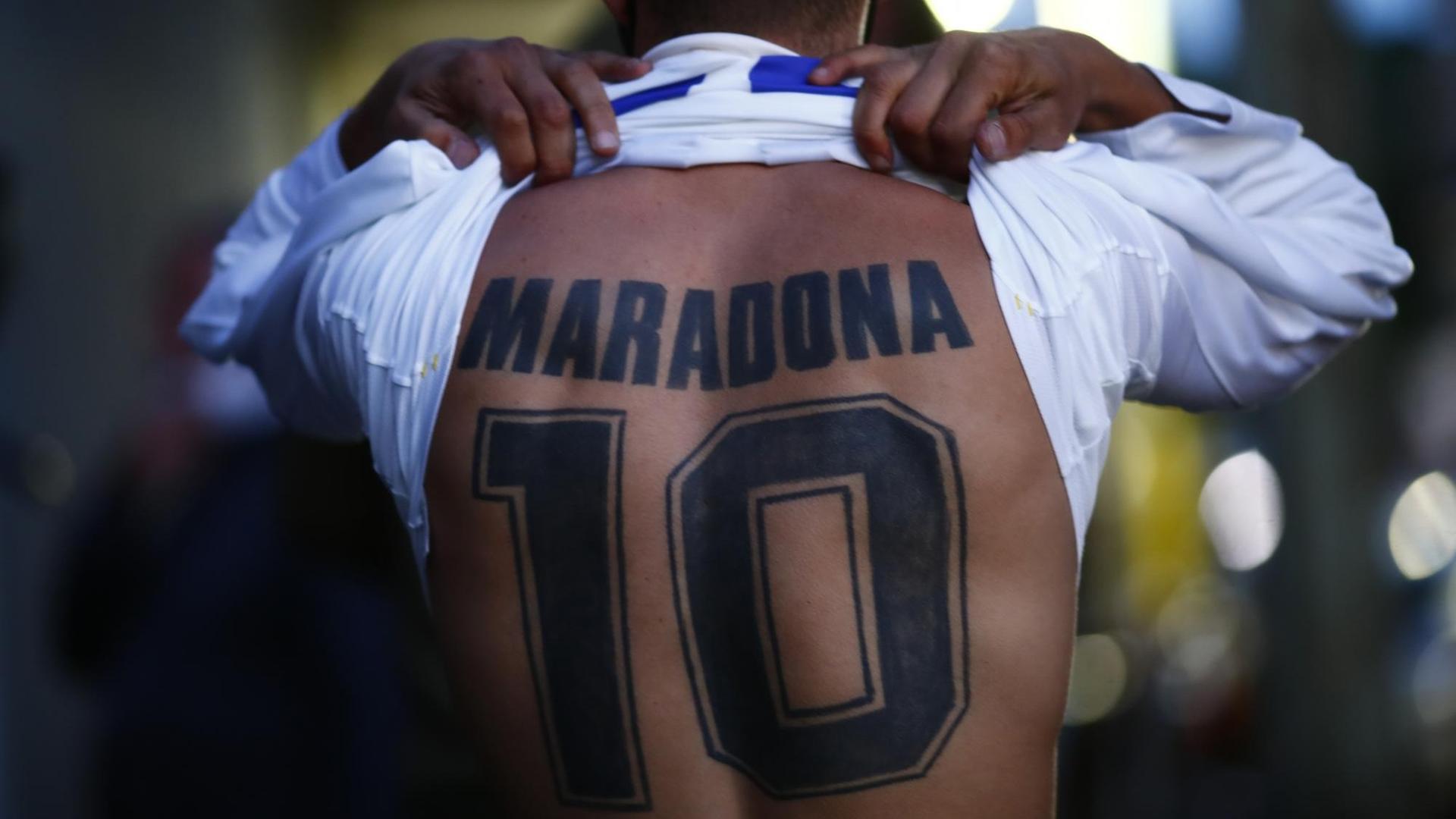 Ein Fan von Diego Maradona hat sich dessen Namen und Rückennummer auf den Rücken tätowieren lassen. Ein Fan von Diego Maradona hat sich dessen Namen und Rückennummer auf den Rücken tätowieren lassen.