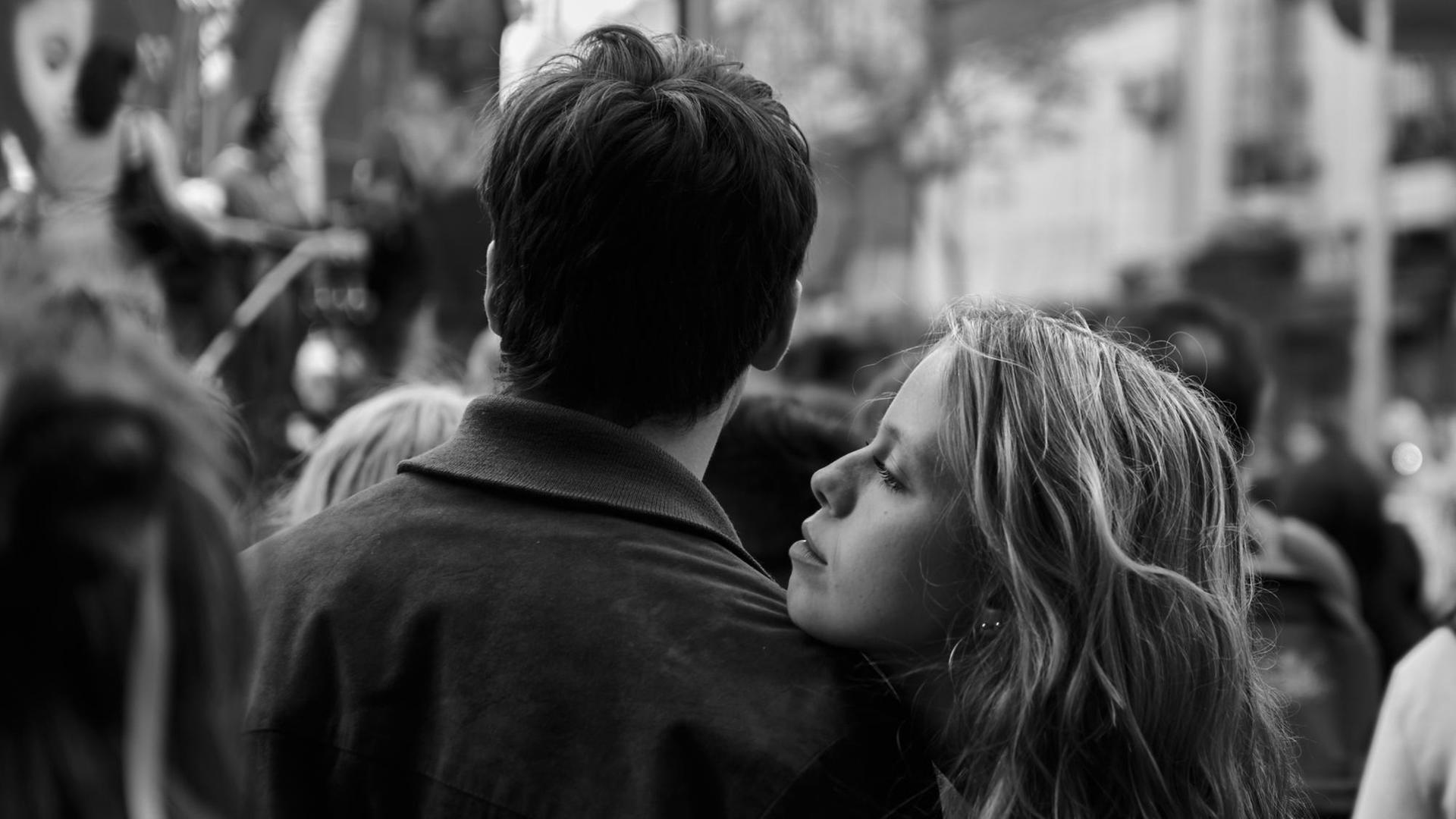 Eine junge Frau legt ihren Kopf auf die Schulter des Partners und schaut ins Leere Eine junge Frau legt ihren Kopf auf die Schulter des Partners und schaut ins Leere