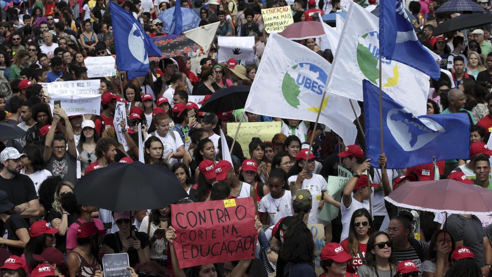 Demonstranten nehmen an einem landesweiten Bildungsstreik in Brasilia teil. Blick von oben auf eine Masse von Demonstranten. Sie schwenken Fahnen und halten Transparente hoch. Demonstranten nehmen an einem landesweiten Bildungsstreik in Brasilia teil. Blick von oben auf eine Masse von Demonstranten. Sie schwenken Fahnen und halten Transparente hoch.