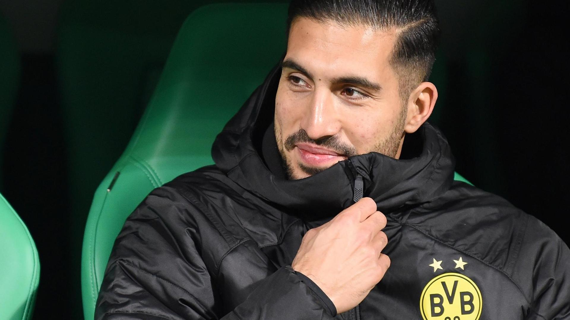Can zieht lächelnd den Reißverschluss seiner schwarzen BVB-Jacke hoch.