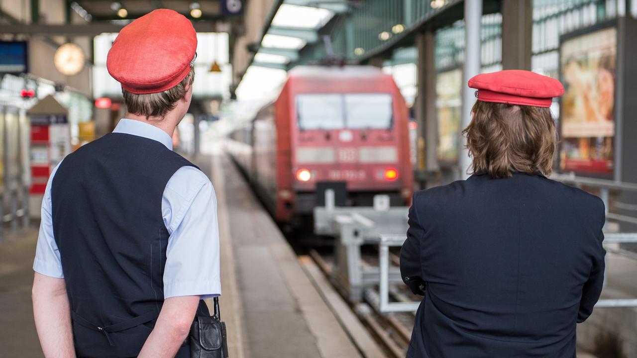 Zwei DB-Mitarbeiter warten am 05.05.2015 im Bahnhof in Stuttgart auf Reisende. Zwei DB-Mitarbeiter warten am 05.05.2015 im Bahnhof in Stuttgart auf Reisende.