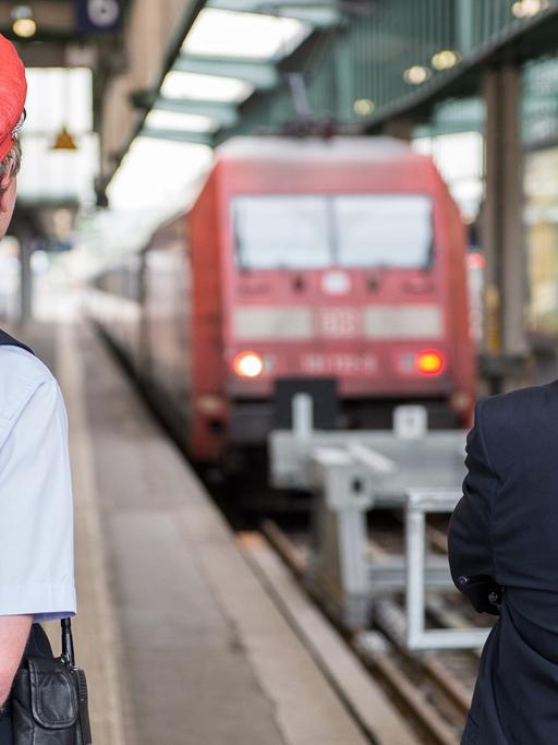 Zwei DB-Mitarbeiter warten am 05.05.2015 im Bahnhof in Stuttgart auf Reisende.