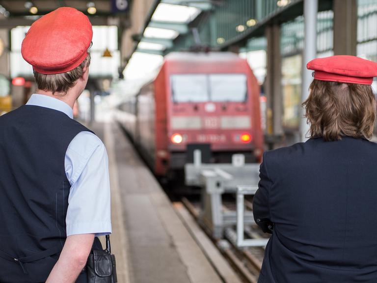 Zwei DB-Mitarbeiter warten am 05.05.2015 im Bahnhof in Stuttgart auf Reisende.