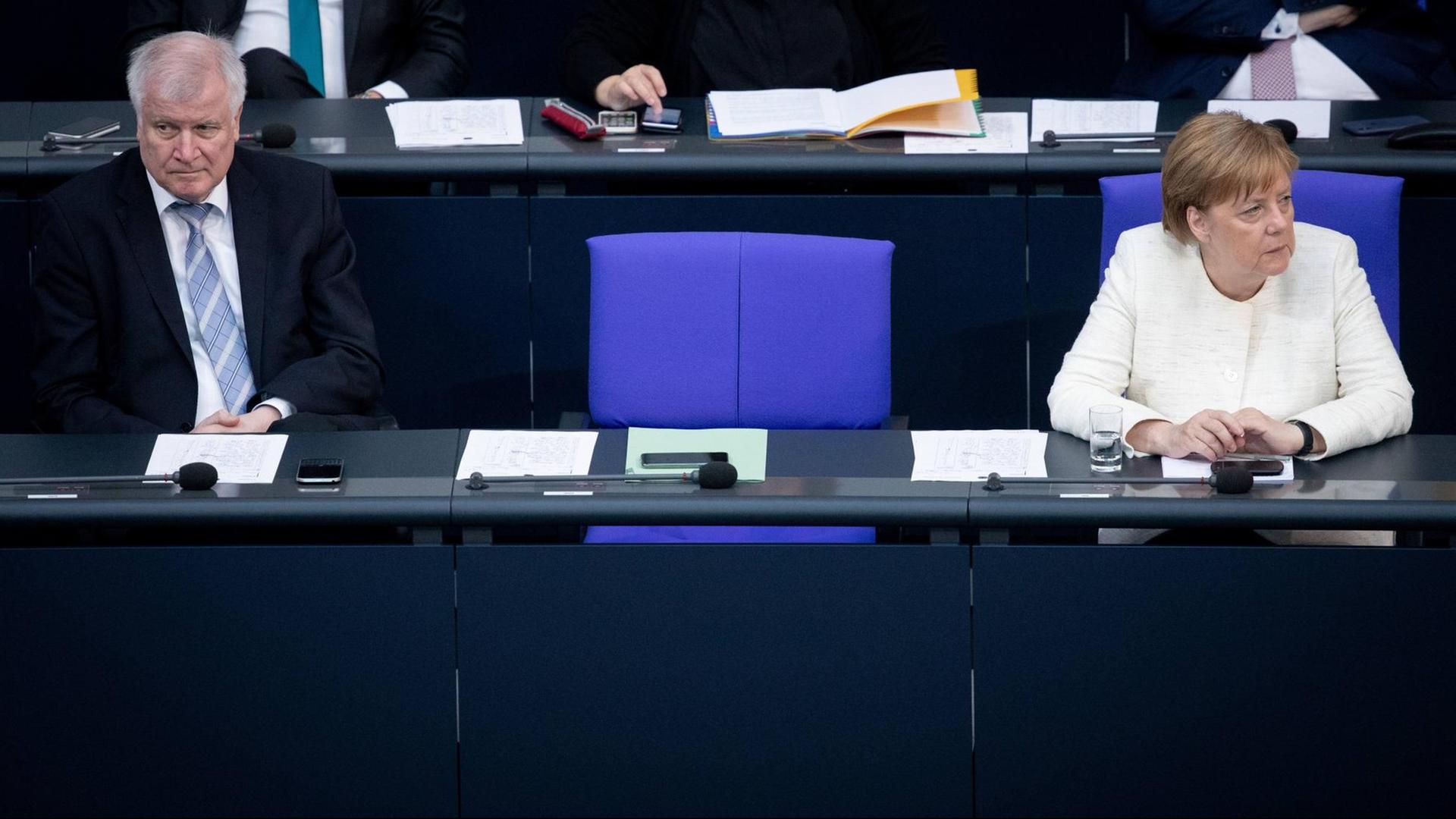 03.07.2018, Berlin: Bundeskanzlerin Angela Merkel (CDU) und Horst Seehofer (CSU), Bundesminister des Innern, für Bau und Heimat, nehmen an der Plenarsitzung im Deutschen Bundestag teil. Im Mittelpunkt der 44. Sitzung der 19. Wahlperiode stehen die Schlussberatungen über den Bundeshaushalt für das laufende Jahr. 03.07.2018, Berlin: Bundeskanzlerin Angela Merkel (CDU) und Horst Seehofer (CSU), Bundesminister des Innern, für Bau und Heimat, nehmen an der Plenarsitzung im Deutschen Bundestag teil. Im Mittelpunkt der 44. Sitzung der 19. Wahlperiode stehen die Schlussberatungen über den Bundeshaushalt für das laufende Jahr.