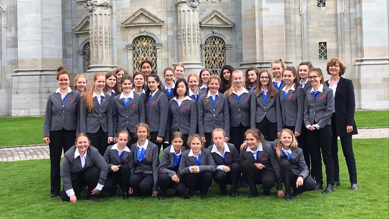 Gruppenbild des Konzertchores vor der Außenmauer einer Kirche. Gruppenbild des Konzertchores vor der Außenmauer einer Kirche.