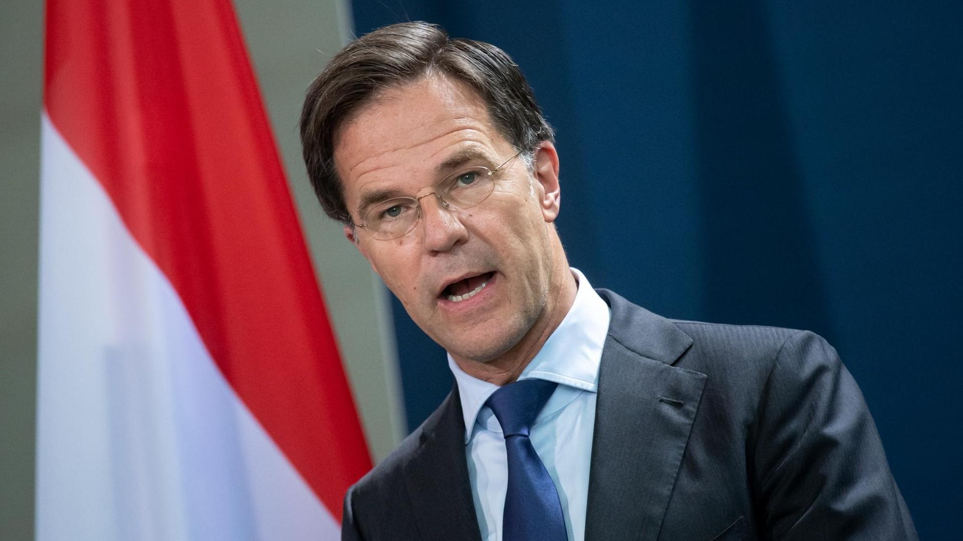 Mark Rutte steht vor einer niederländischen Flagge.
Mark Rutte steht vor einer niederländischen Flagge.