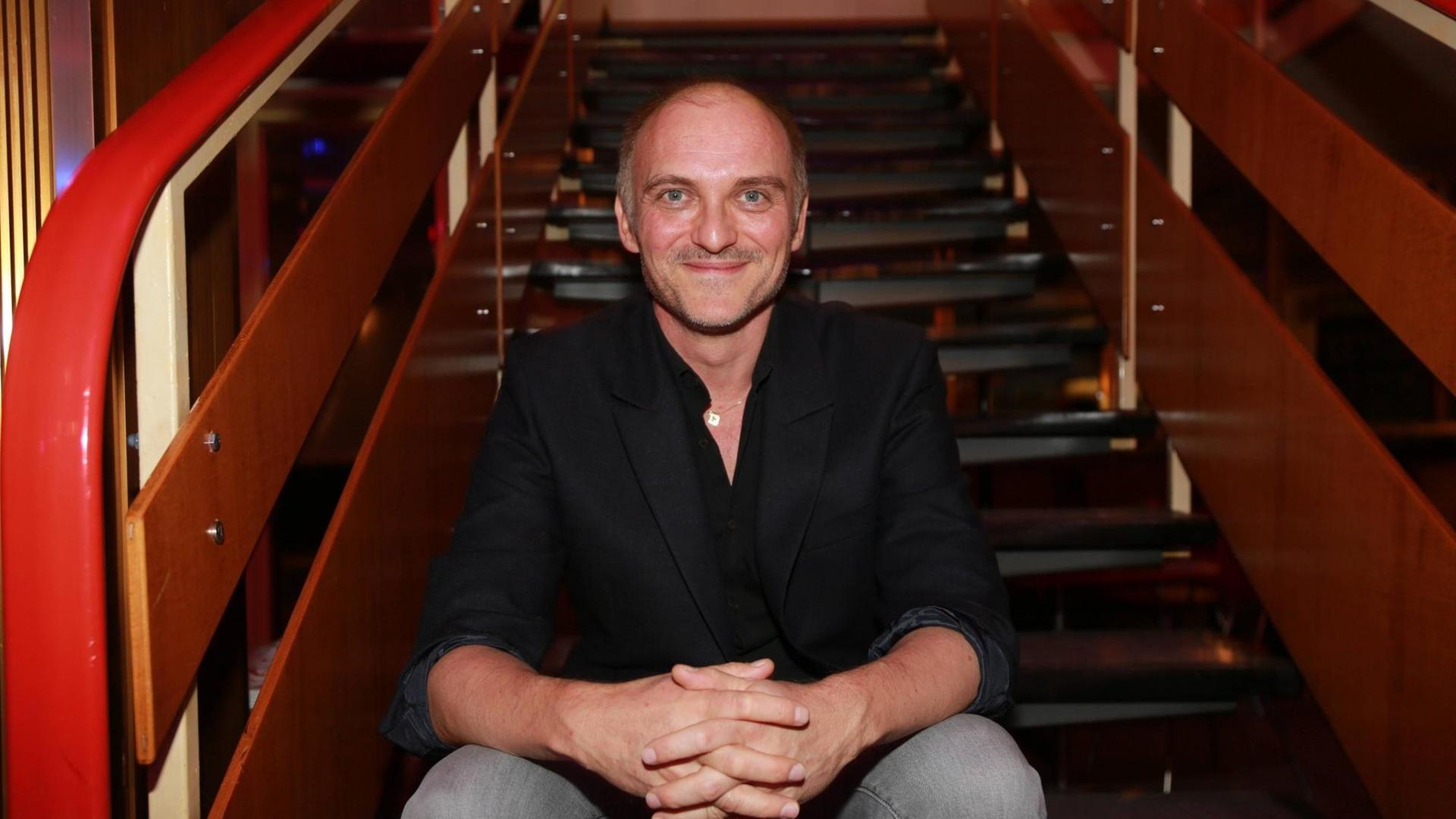 Der Schauspieler Markus Schleinzer sitzt auf einer Treppe Der Schauspieler Markus Schleinzer sitzt auf einer Treppe