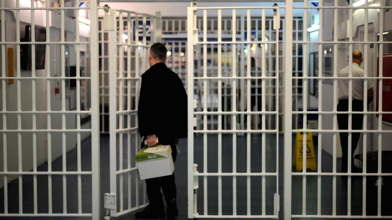 Mann mit Paket vor Gittertür in einem britischen Gefängnis Mann mit Paket vor Gittertür in einem britischen Gefängnis