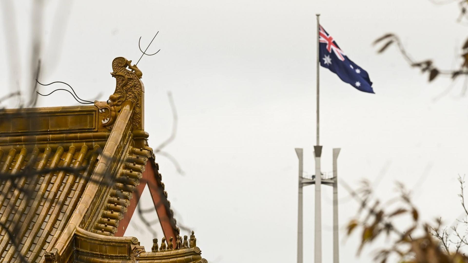 Flagge des australischen Parlament hinter dem Dachstuhl der chinesischen Botschaft in Canbera Flagge des australischen Parlament hinter dem Dachstuhl der chinesischen Botschaft in Canbera