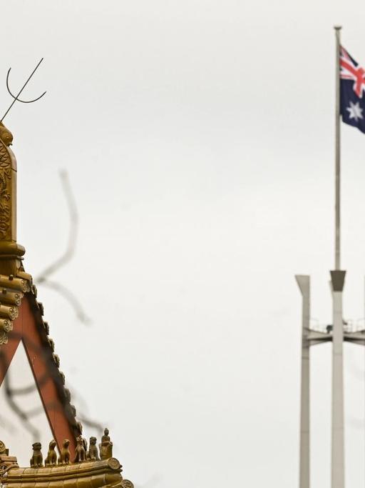 Flagge des australischen Parlament hinter dem Dachstuhl der chinesischen Botschaft in Canbera