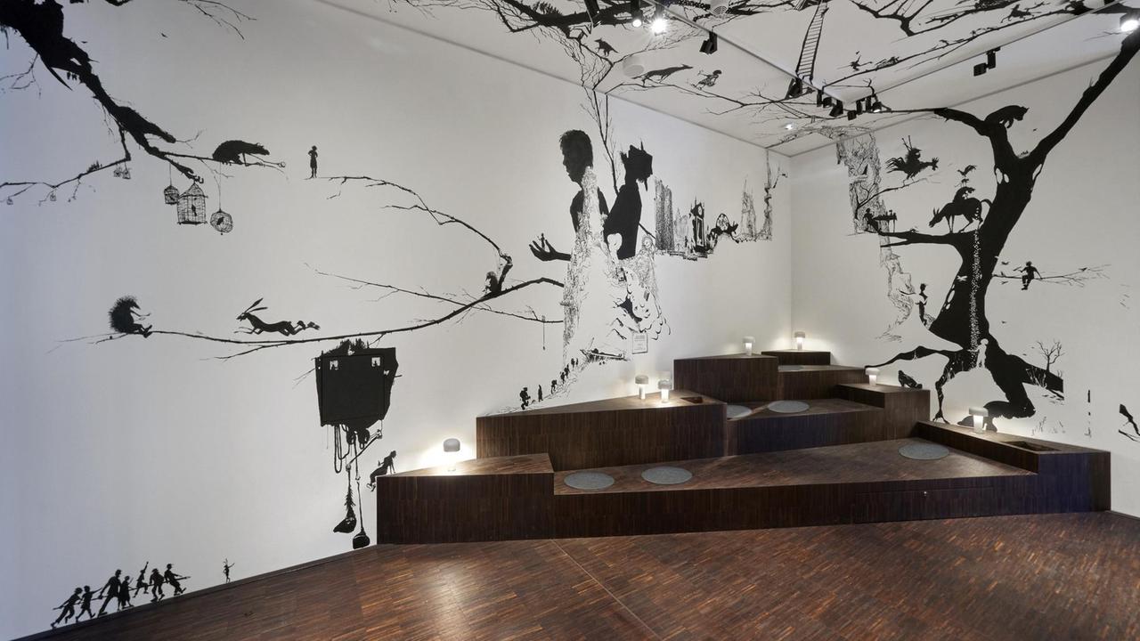 Auf weißer Wand sind Silhouetten von Märchenfiguren der Brüder Grimm zu sehen. Auf weißer Wand sind Silhouetten von Märchenfiguren der Brüder Grimm zu sehen.