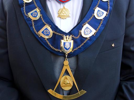 Detailansicht des goldenen Ordensschmucks eines Großmeisters der Freimaurer mit Freimaurersymbolen.