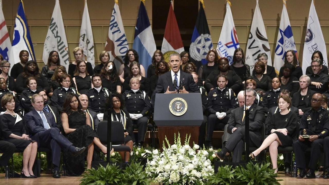 US-Präsident Barack Obama spricht bei dem Trauergottesdienst in Dallas. Hiter ihm sitzen zahlreiche Polizisten. US-Präsident Barack Obama spricht bei dem Trauergottesdienst in Dallas. Hiter ihm sitzen zahlreiche Polizisten.