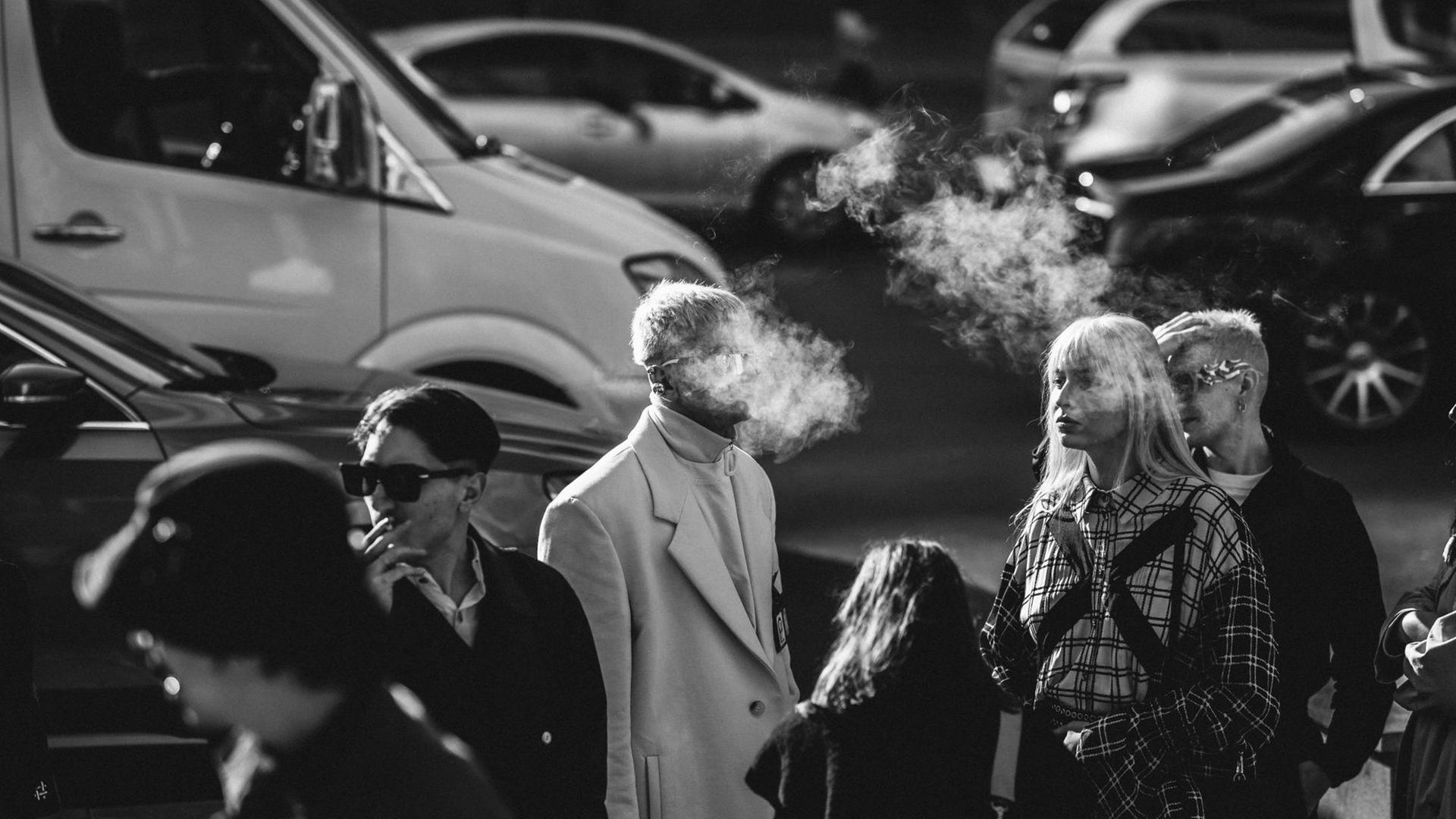 An einer Straßenkreuzung, steigt der Zigarettenqualm einiger Raucher in die Luft. An einer Straßenkreuzung, steigt der Zigarettenqualm einiger Raucher in die Luft.