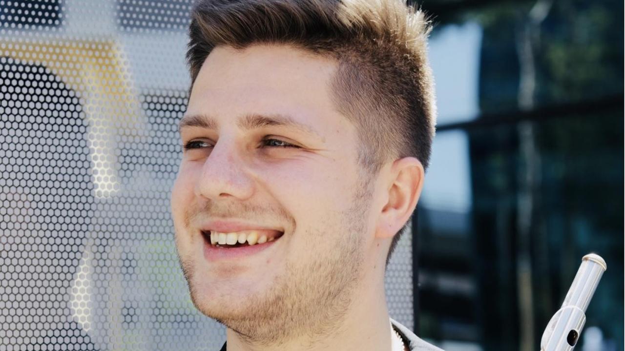 Matvey Demin hält seine Flöte in der rechten Hand, blickt nach rechts. Matvey Demin hält seine Flöte in der rechten Hand, blickt nach rechts.