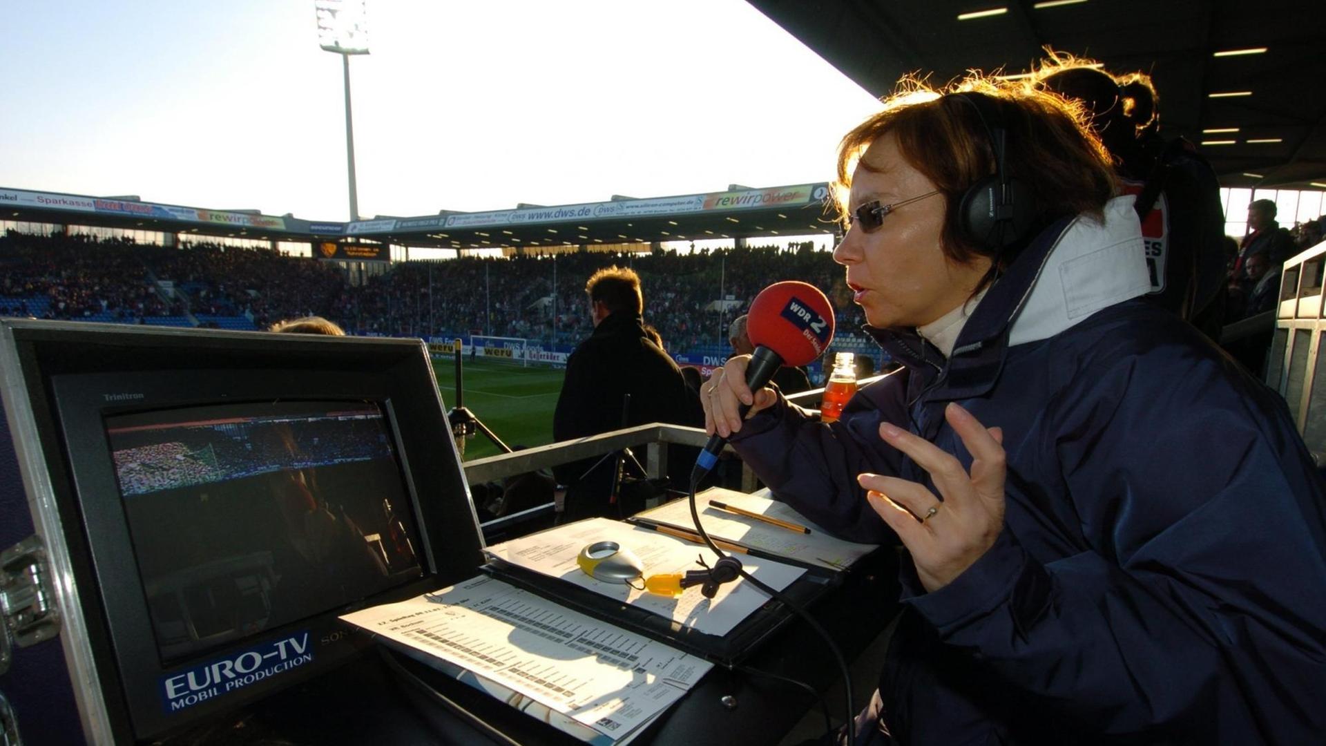 Sabine Töpperwien im Fußball-Stadion mit Mikrofon vor dem Mund