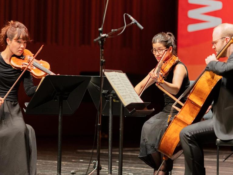 Die Musiker sitzen auf der Bühne und spielen leidenschaftlich
