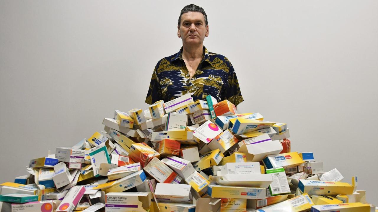 Der schottische Künstler Brian Keeley, vor ihm türmen sich Verpackungen von Medikamenten.