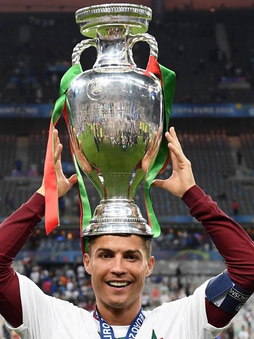Der portugiesische Stürmer Cristiano Ronaldo trägt den EM-Pokal auf dem Kopf.