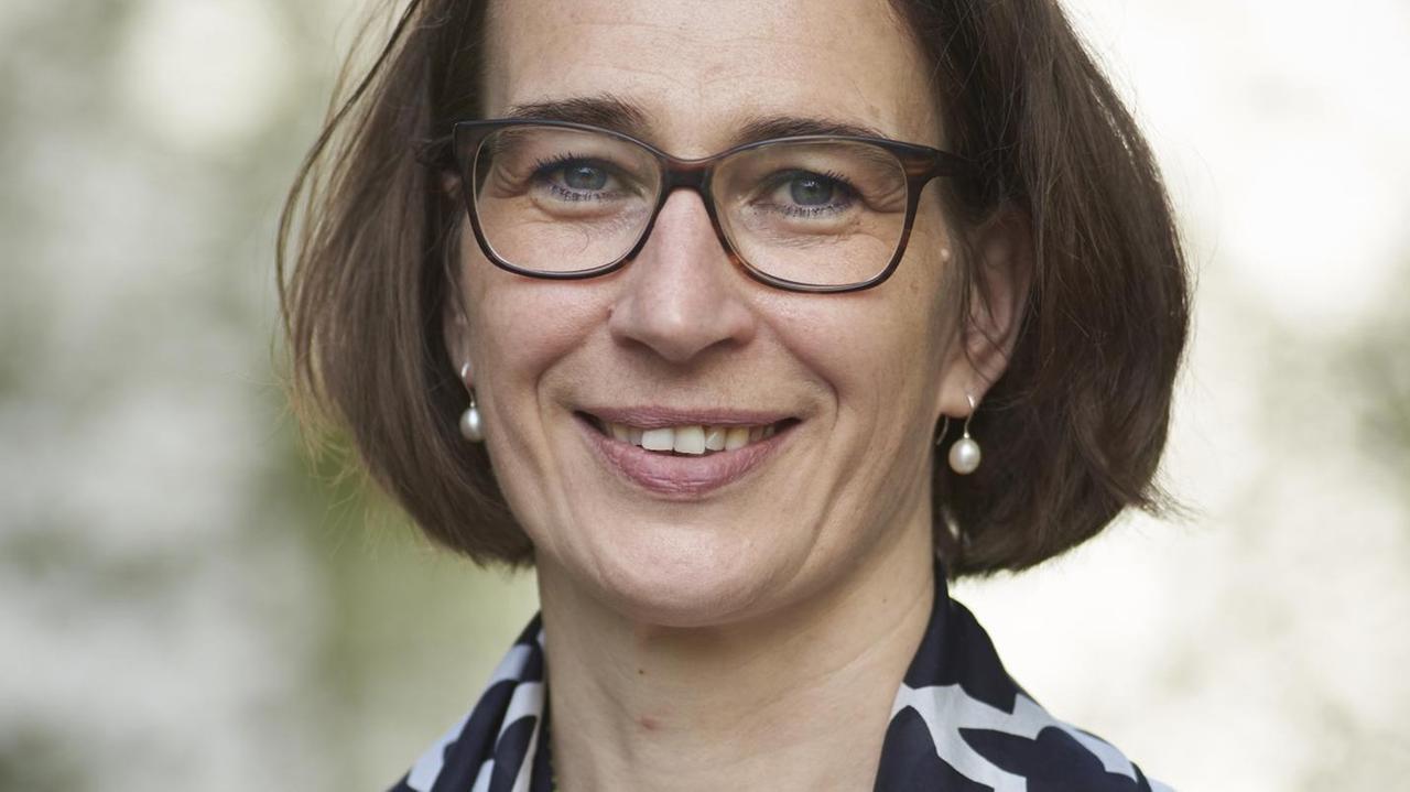 Die Politologin Sandra Seubert, mit Brille, in einer weißen Bluse mit schwarz gemustertem Seidentuch über den Schultern, lächelt in die Kamera Die Politologin Sandra Seubert, mit Brille, in einer weißen Bluse mit schwarz gemustertem Seidentuch über den Schultern, lächelt in die Kamera