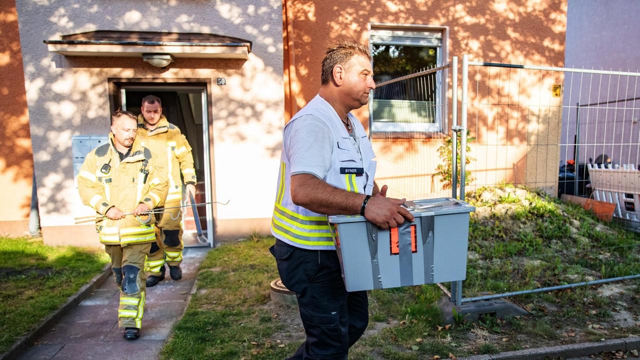 Reptilienexperte Roland Byner trägt die entwischte Monokelkobra in einem Behälter aus einem Hauseingang. Am 25. August war im Treppenhaus eines Mehrfamilienhauses eine hochgiftige Monokelkobra mit einer geschätzten Länge von mindestens 1,40 Metern gesichtet worden. Mehrere Mehrfamilienhäuser wurden evakuiert. Das Tier wurde schließlich gefangen. Reptilienexperte Roland Byner trägt die entwischte Monokelkobra in einem Behälter aus einem Hauseingang. Am 25. August war im Treppenhaus eines Mehrfamilienhauses eine hochgiftige Monokelkobra mit einer geschätzten Länge von mindestens 1,40 Metern gesichtet worden. Mehrere Mehrfamilienhäuser wurden evakuiert. Das Tier wurde schließlich gefangen.