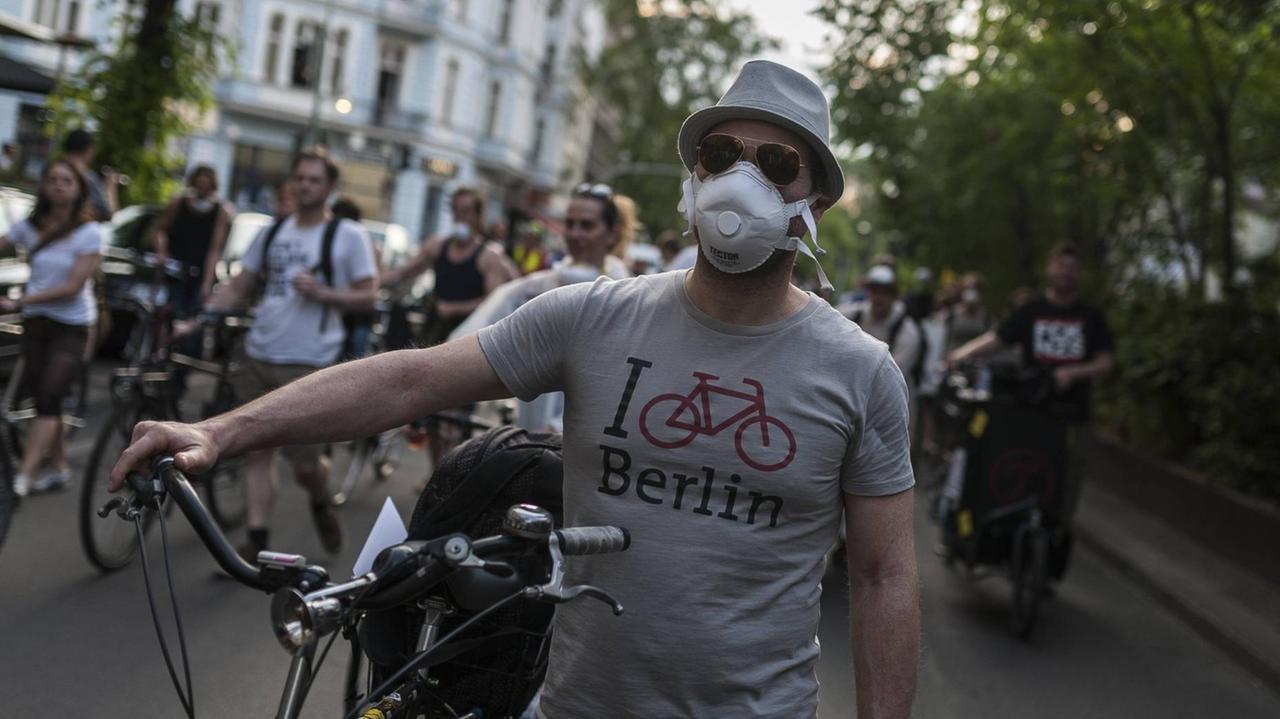 Ein junger Mann mit Atemmaske auf einer Anti-Feinstaub-Demo in Berlin-Neuköllnläuft während einer Feinstaub-Demo in Berlin-Neukölln. Ein junger Mann mit Atemmaske auf einer Anti-Feinstaub-Demo in Berlin-Neuköllnläuft während einer Feinstaub-Demo in Berlin-Neukölln.