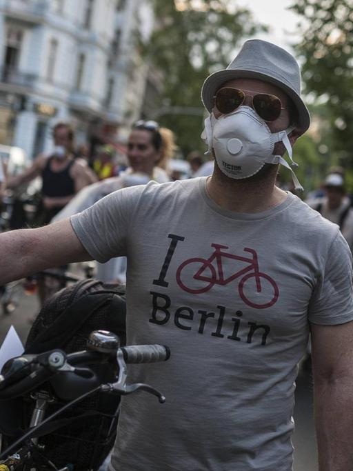 Ein junger Mann mit Atemmaske auf einer Anti-Feinstaub-Demo in Berlin-Neuköllnläuft während einer Feinstaub-Demo in Berlin-Neukölln.