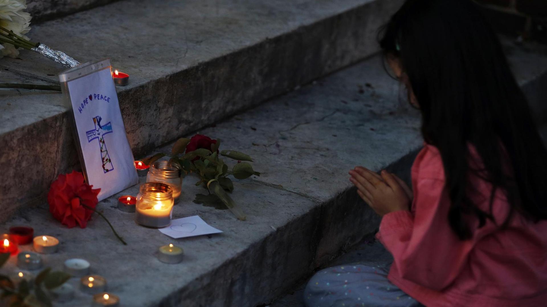 Ein Mädchen betet am Rathaus von Saint-Étienne-du-Rouvray in der Normandie, wo zwei Attentäter einen Priester getötet hatten.