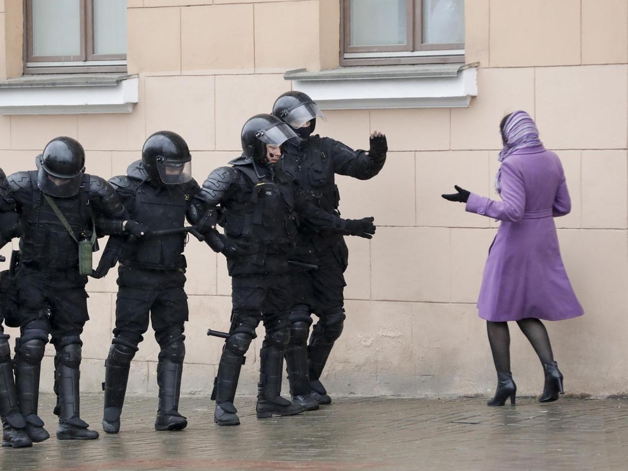 Eine Frau diskutiert am 25.03.2017 in Minsk (Weißrussland) mit mehreren schwer bewaffneten Polizisten auf einer Demonstration. 