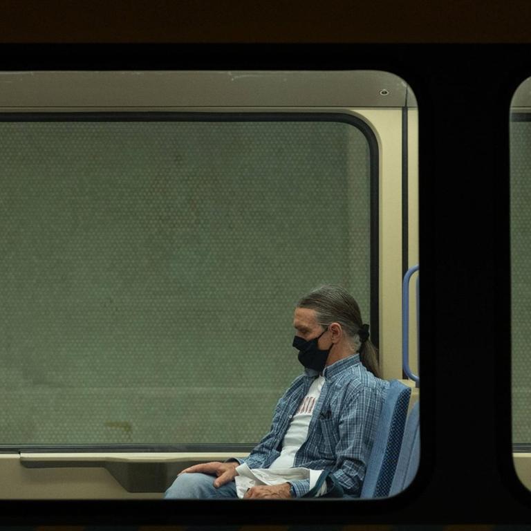 Ein Mann sitzt mit einer Schutzmaske in der Stuttgarter U-Bahn.