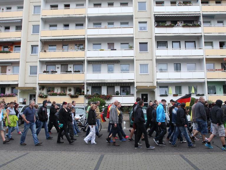 Teilnehmer eines Rechten Aufmarsches laufen am 28.08.2015 in Heidenau (Sachsen) eine Straße entlang