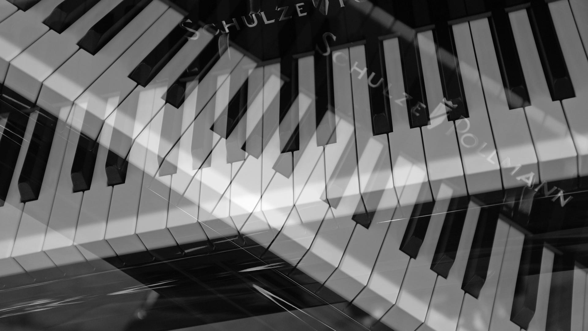 Ein mehrfach belichtetes Foto zeigt zwei gekreuzte Piano-Klaviaturen. Ein mehrfach belichtetes Foto zeigt zwei gekreuzte Piano-Klaviaturen.