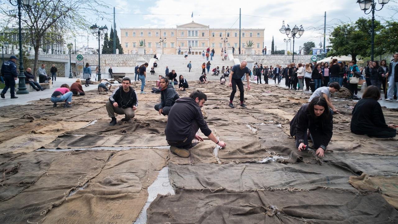 Helfer nähen auf dem Syntagma-Platz unzählige gebrauchte Jutesäcke zu einem Teppich zusammen Helfer nähen auf dem Syntagma-Platz unzählige gebrauchte Jutesäcke zu einem Teppich zusammen