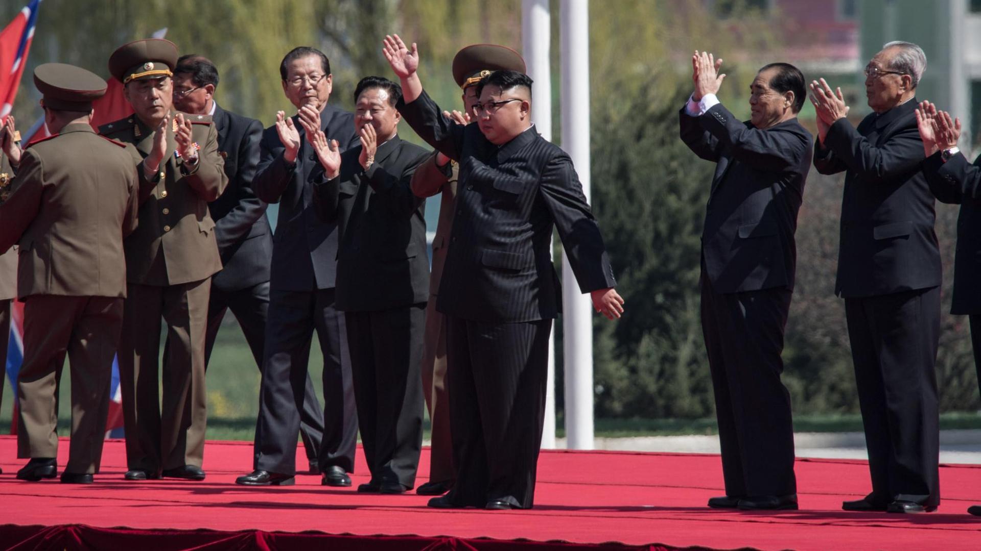 Der nordkoreanische Machthaber Kim Jong-Un (m.) winkt bei einer Feier anlässlich einer Straßeneinweihung in Pjöngjang.