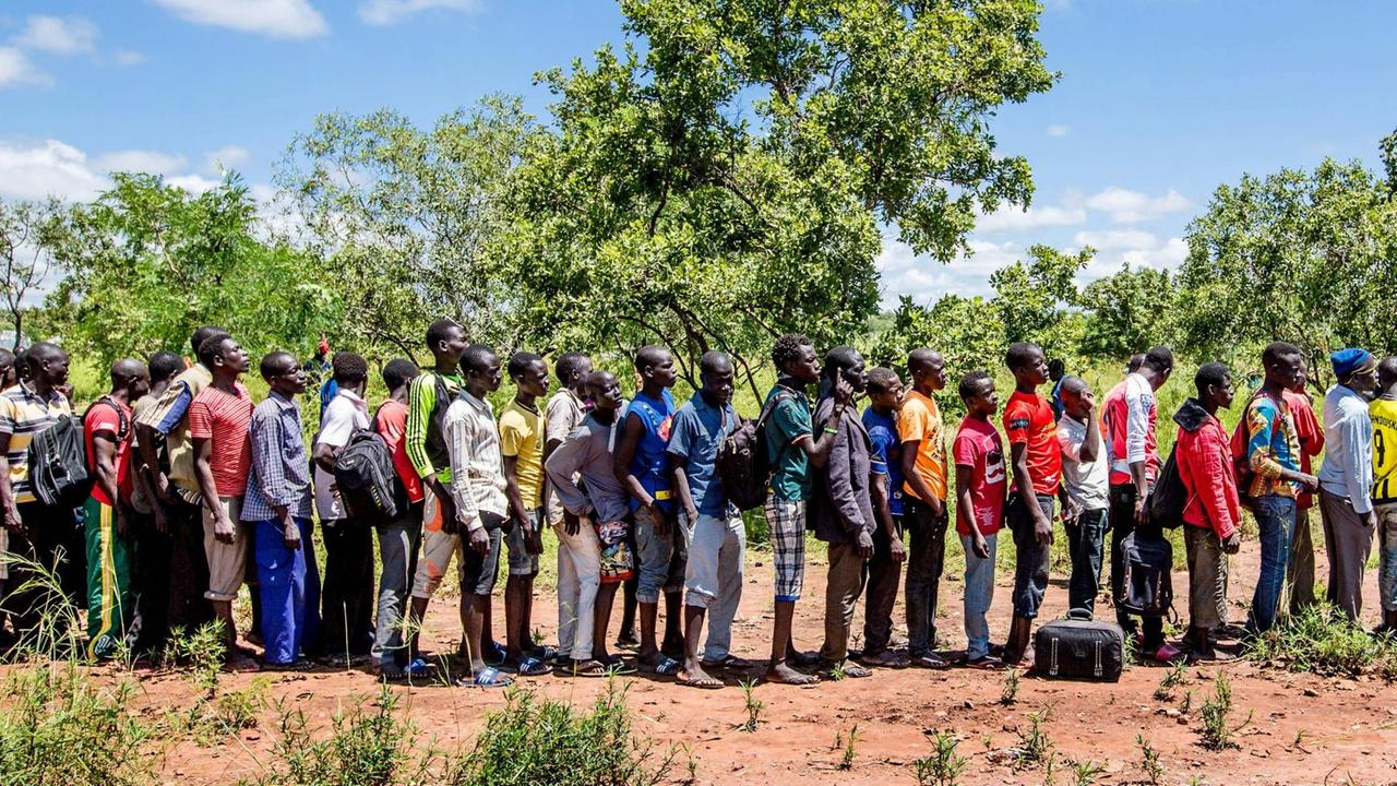 Flüchtlinge aus dem Südsudan in der Flüchtlingssiedlung Omugo im Norden Ugandas stehen in einer Schlange an Flüchtlinge aus dem Südsudan in der Flüchtlingssiedlung Omugo im Norden Ugandas stehen in einer Schlange an