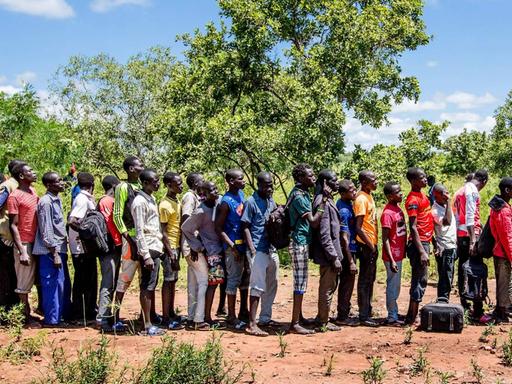 Flüchtlinge aus dem Südsudan in der Flüchtlingssiedlung Omugo im Norden Ugandas stehen in einer Schlange an