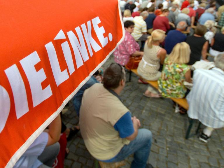 Schweriner Bürger hören in Schwerin bei einer Wahlkampfveranstaltung der Partei Die Linke einer Rede zu.