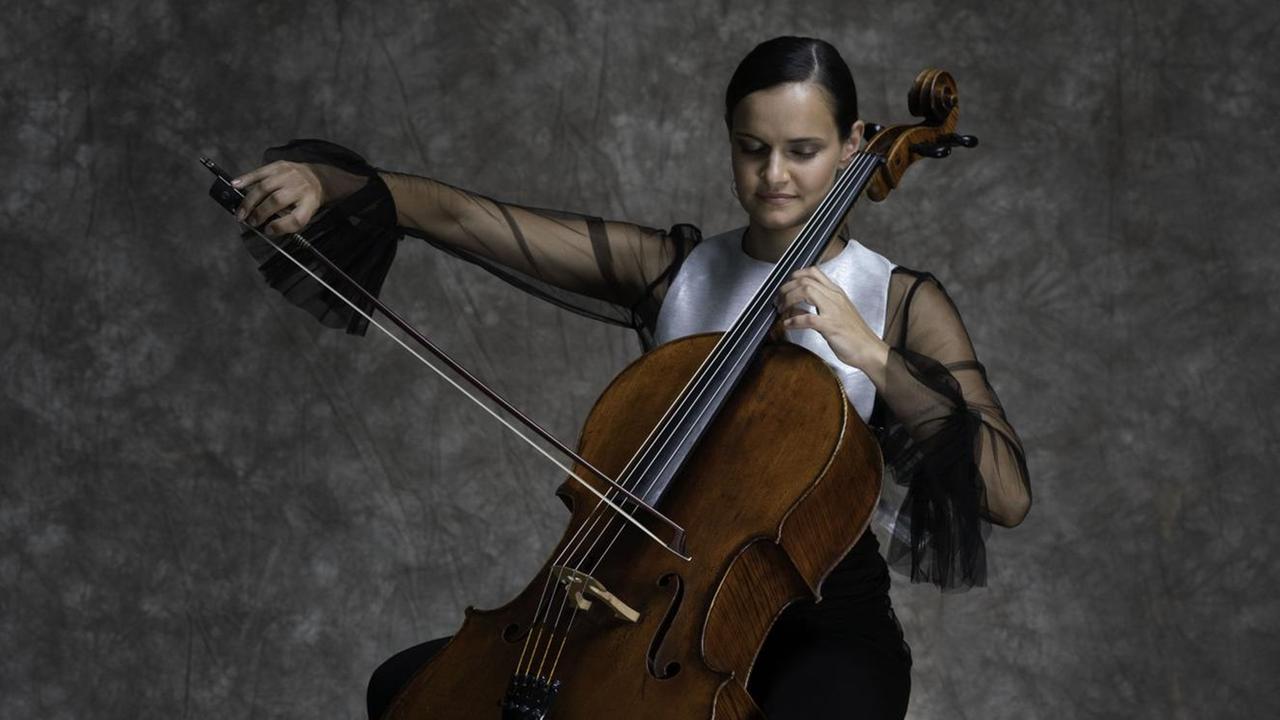 Die Cellistin spielt mit ausladender Geste ihr Violoncello. Die Cellistin spielt mit ausladender Geste ihr Violoncello.