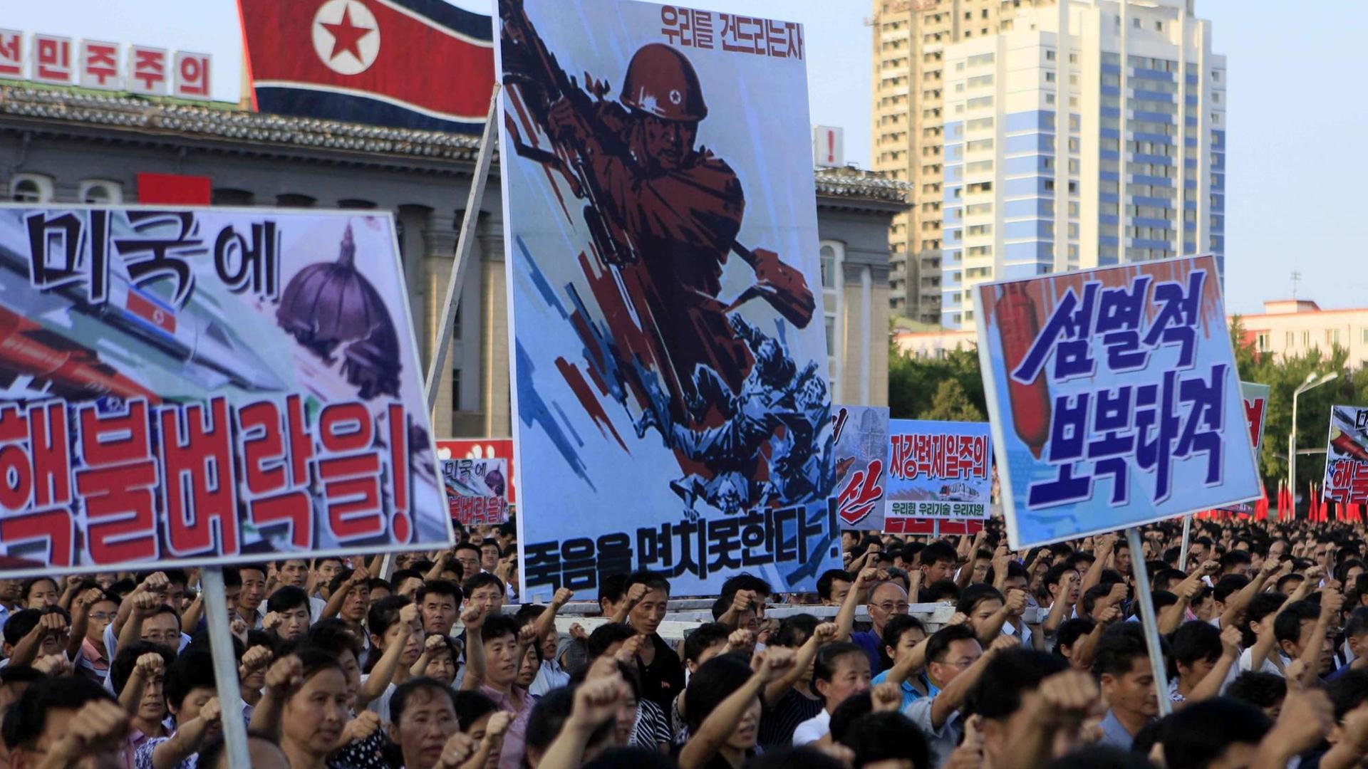 Zehntausende Nordkoreaner versammeln sich am 09.08.2017 auf dem Kim-Il-sung-Platz in Pjöngjang (Nordkorea) zu einer Demonstration gegen die UN-Sanktionen. Ihre Plakate bekunden die Unterstützung der Regierung.