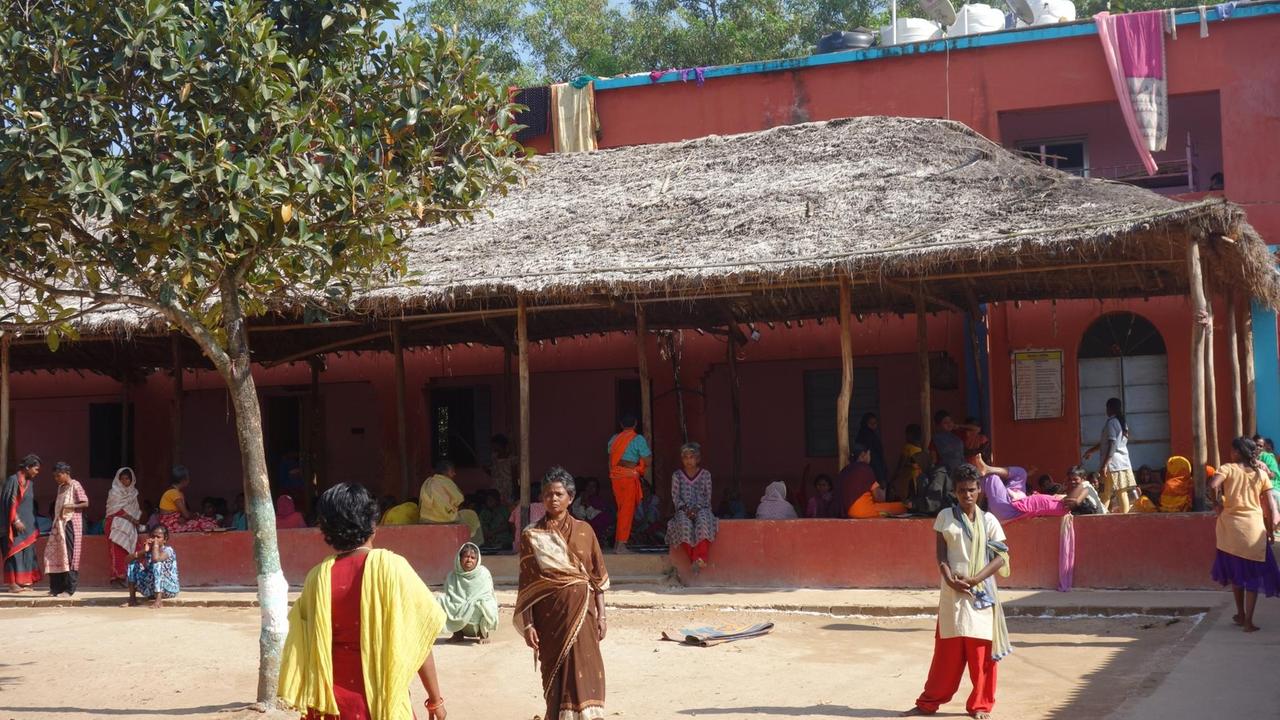 Lang gestreckte rot gestrichene Gebäude mit Vordach und Hof - Mission Ashra für psychisch kranke Fraun im indischen Staat Odisha