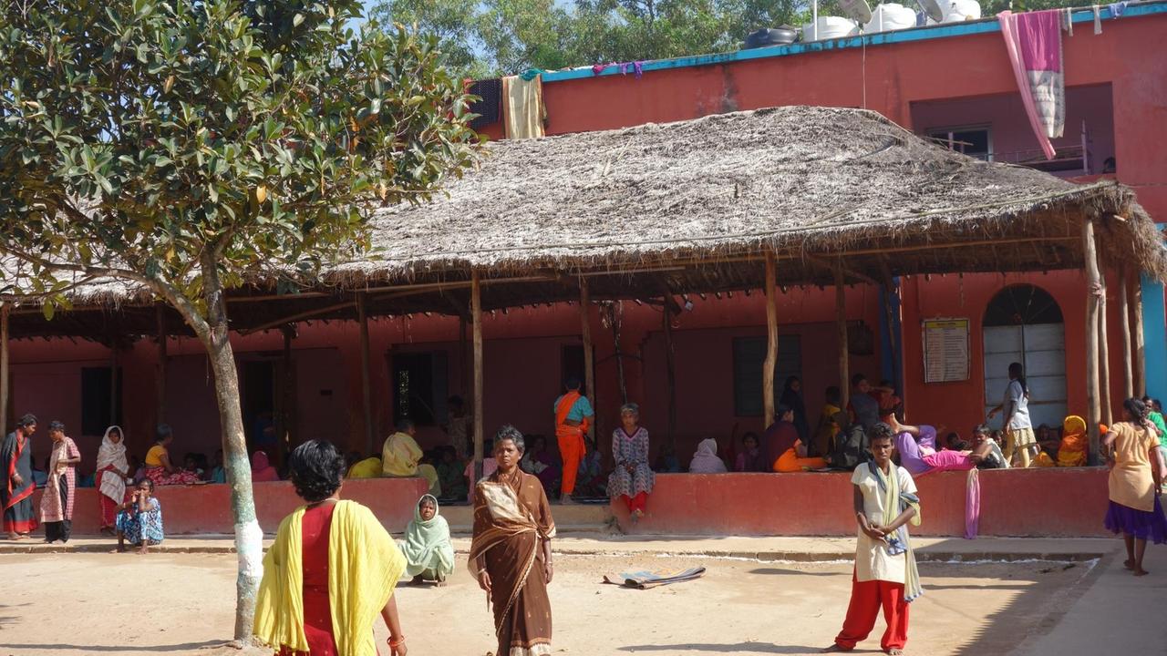 Lang gestreckte rot gestrichene Gebäude mit Vordach und Hof - Mission Ashra für psychisch kranke Fraun im indischen Staat Odisha Lang gestreckte rot gestrichene Gebäude mit Vordach und Hof - Mission Ashra für psychisch kranke Fraun im indischen Staat Odisha