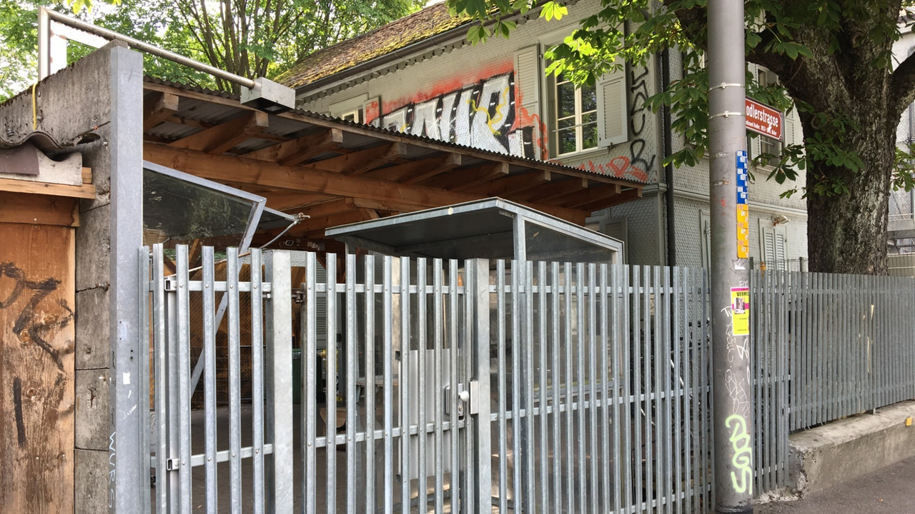 Ein kleines Gebäude hinter einem Sicherheitszaun Ein kleines Gebäude hinter einem Sicherheitszaun