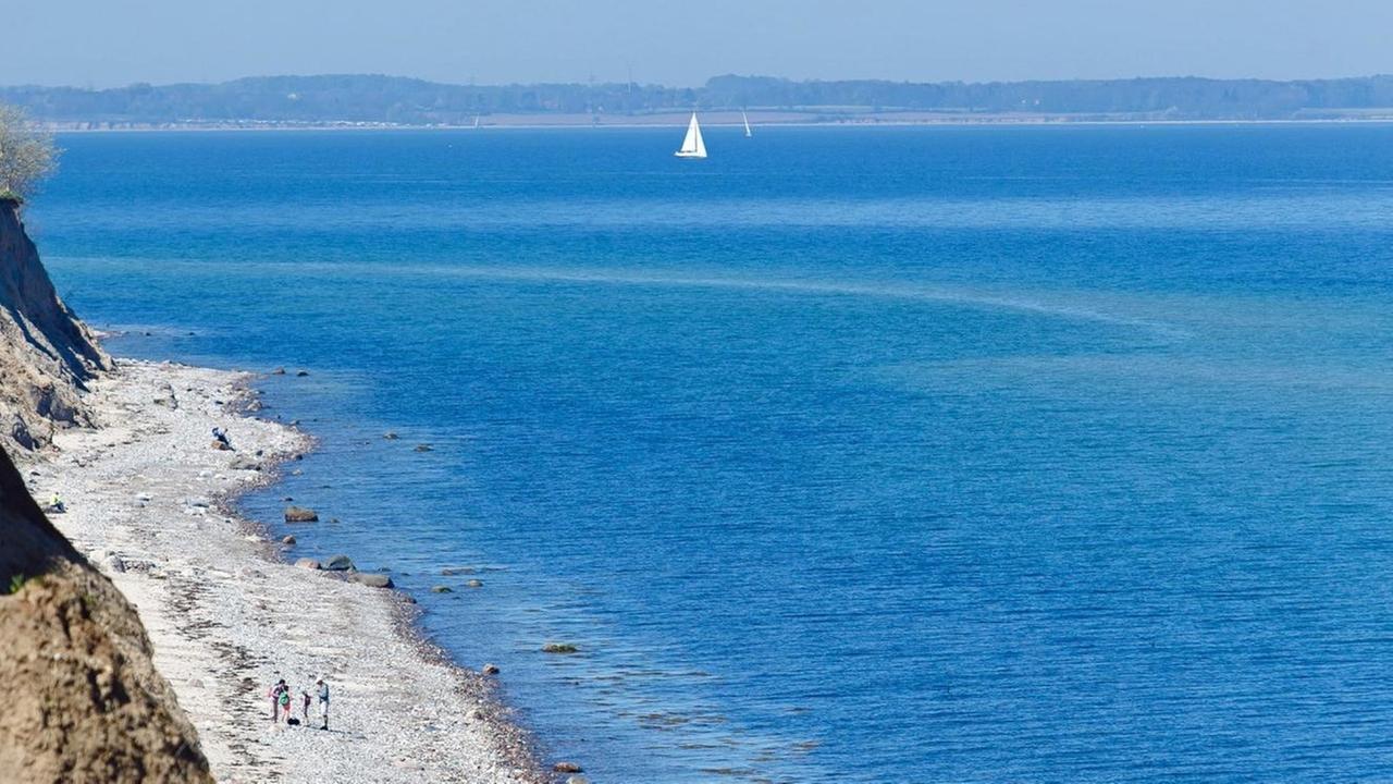 Fußgänger spazieren in Schwedeneck entlang der Steilküste am Ostseestrand Fußgänger spazieren in Schwedeneck entlang der Steilküste am Ostseestrand