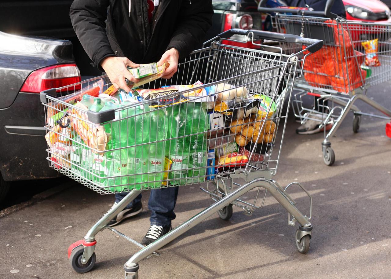 Ein Mann steht am 02.03.2020 mit einem vollen Einkaufswagen vor einem Supermarkt in Berlin. 
