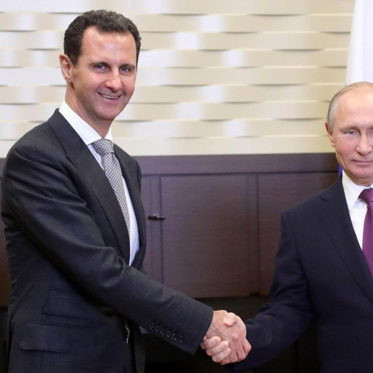 Der russische Präsident Wladimir Putin (rechts) und Syriens Präsident Baschar al-Assad (links) geben sich am 20.11.2017 in Sotschi (Russland) die Hand.