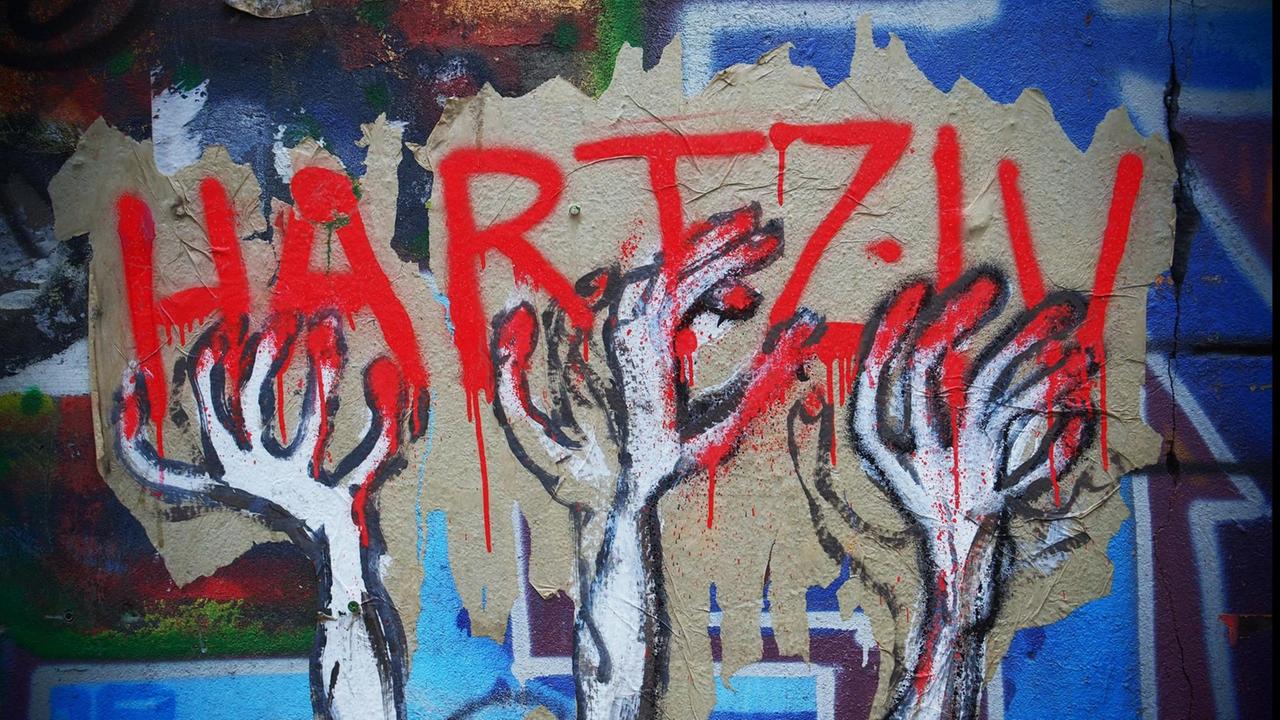 Das Bild zeigt ein Graffiti in Berlin, das die Hartz-IV-Gesetze kritisiert.