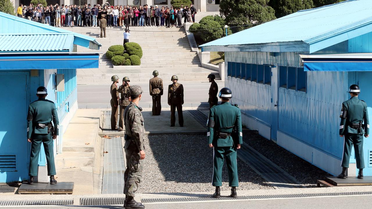 Südkoreranische (im Vordergrund) und nordkoreanische Soldaten stehen sich in der Demilitarisierten Zone an den Blauen Baracken an der Grenze zu Nordkorea gegenüber. Südkoreranische (im Vordergrund) und nordkoreanische Soldaten stehen sich in der Demilitarisierten Zone an den Blauen Baracken an der Grenze zu Nordkorea gegenüber.