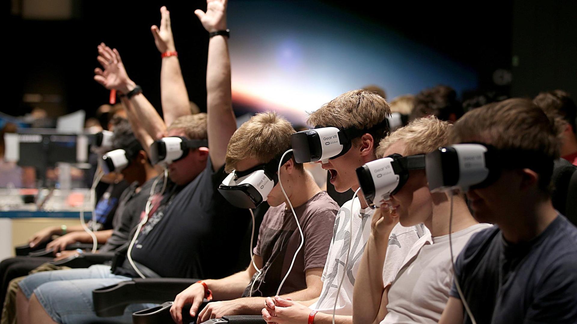 Besucher der Gamescom machen am 23.08.2017 in Köln mit einer Gear-VR Brille eine Achterbahnfahrt. Besucher der Gamescom machen am 23.08.2017 in Köln mit einer Gear-VR Brille eine Achterbahnfahrt.