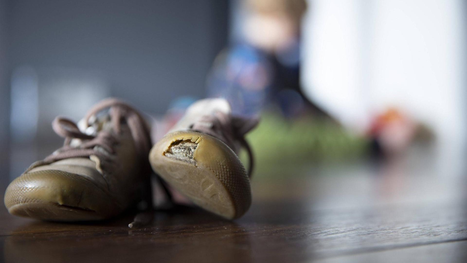 Ein paar Kinderschuhe mit Löchern. Ein paar Kinderschuhe mit Löchern.