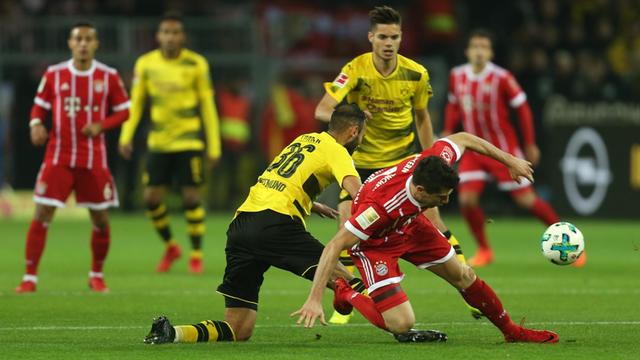 Das Bild zeigt eine Spielszene aus der Bundesliga-Begegnung Borussia Dortmund - Bayern München. Ömer Toprak von Dortmund und Robert Lewandowski (r) von München kämpfen um den Ball.